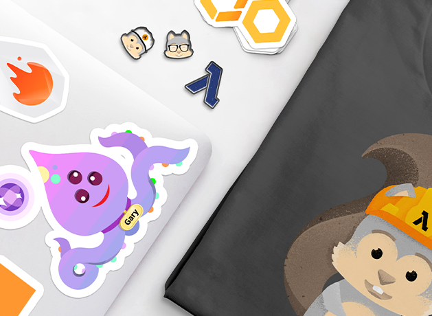 Cartoon stickers on a laptop next to a folded T-shirt with a mascot print