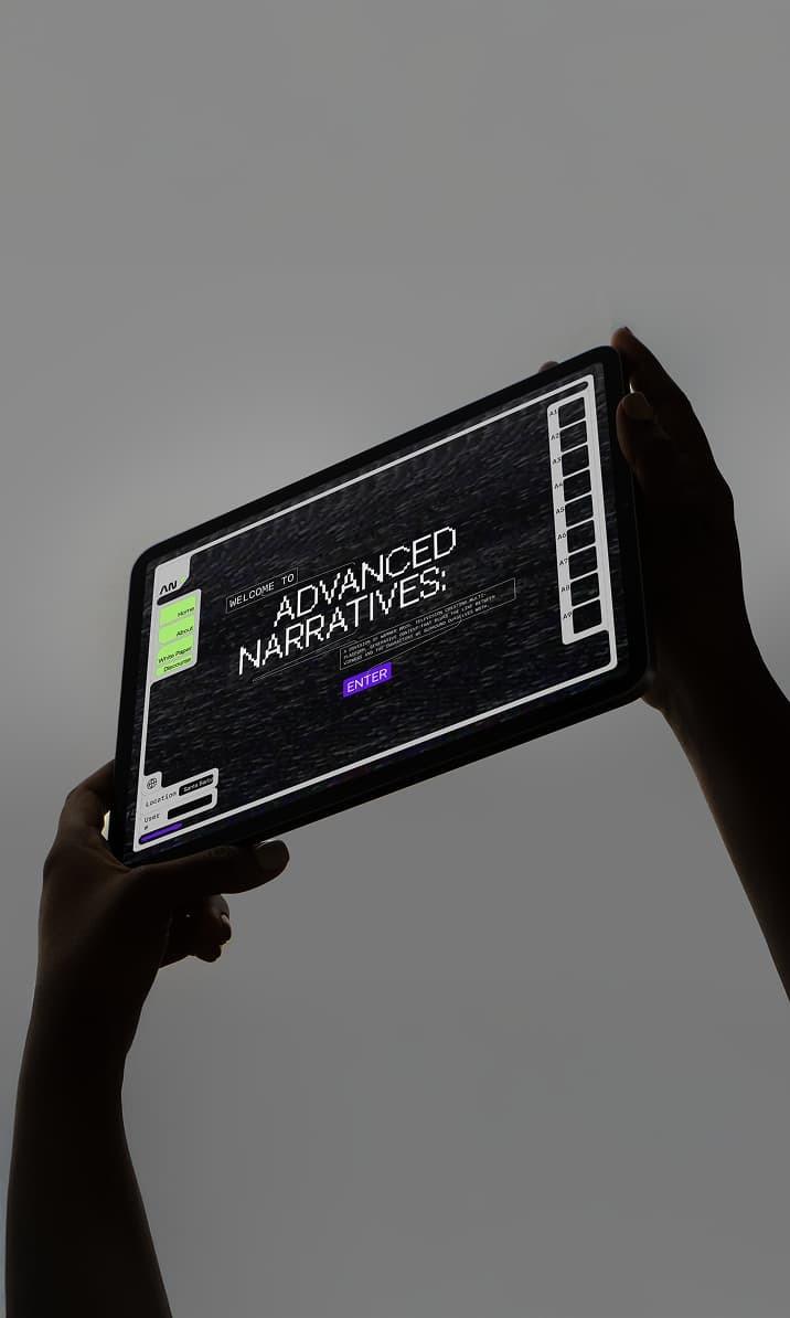 Hands hold a tablet showing an Advanced Narratives interface.