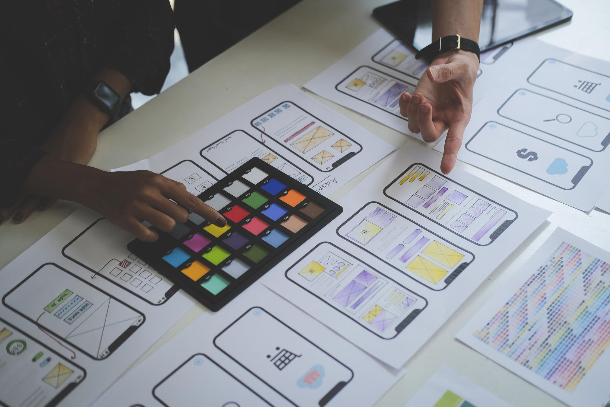 Team reviewing mobile app wireframes and color swatches