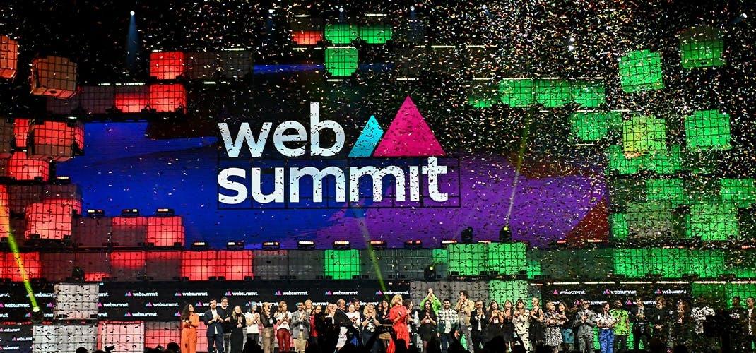 Web Summit closing ceremony, speakers on stage under confetti and a lit LED wall