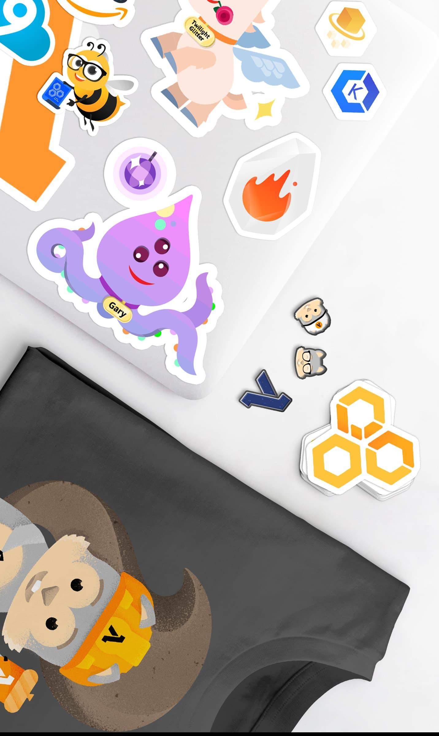 AWS character stickers spread on a white surface beside a dark printed T-shirt