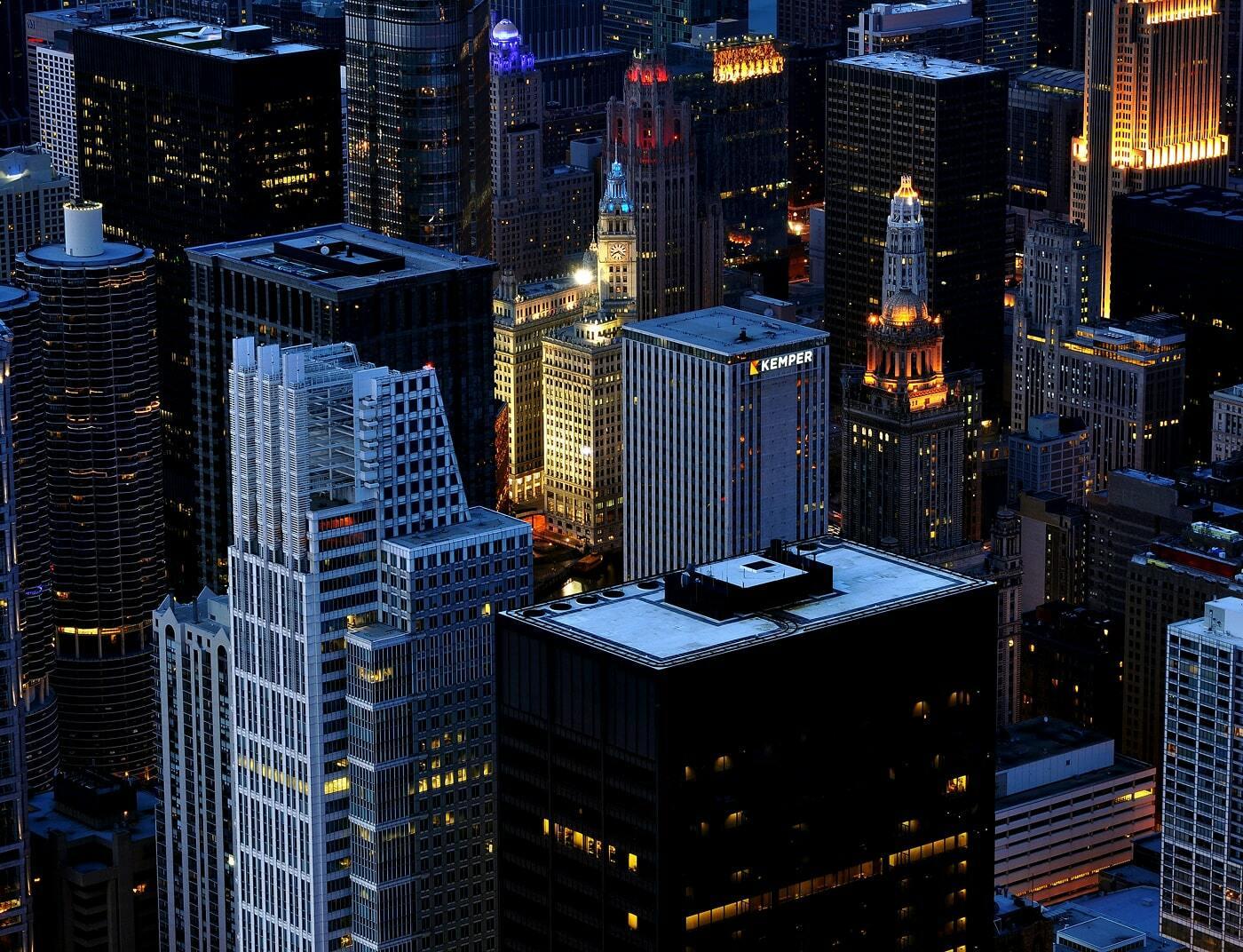 Downtown skyscrapers at dusk with illuminated office towers and city lights
