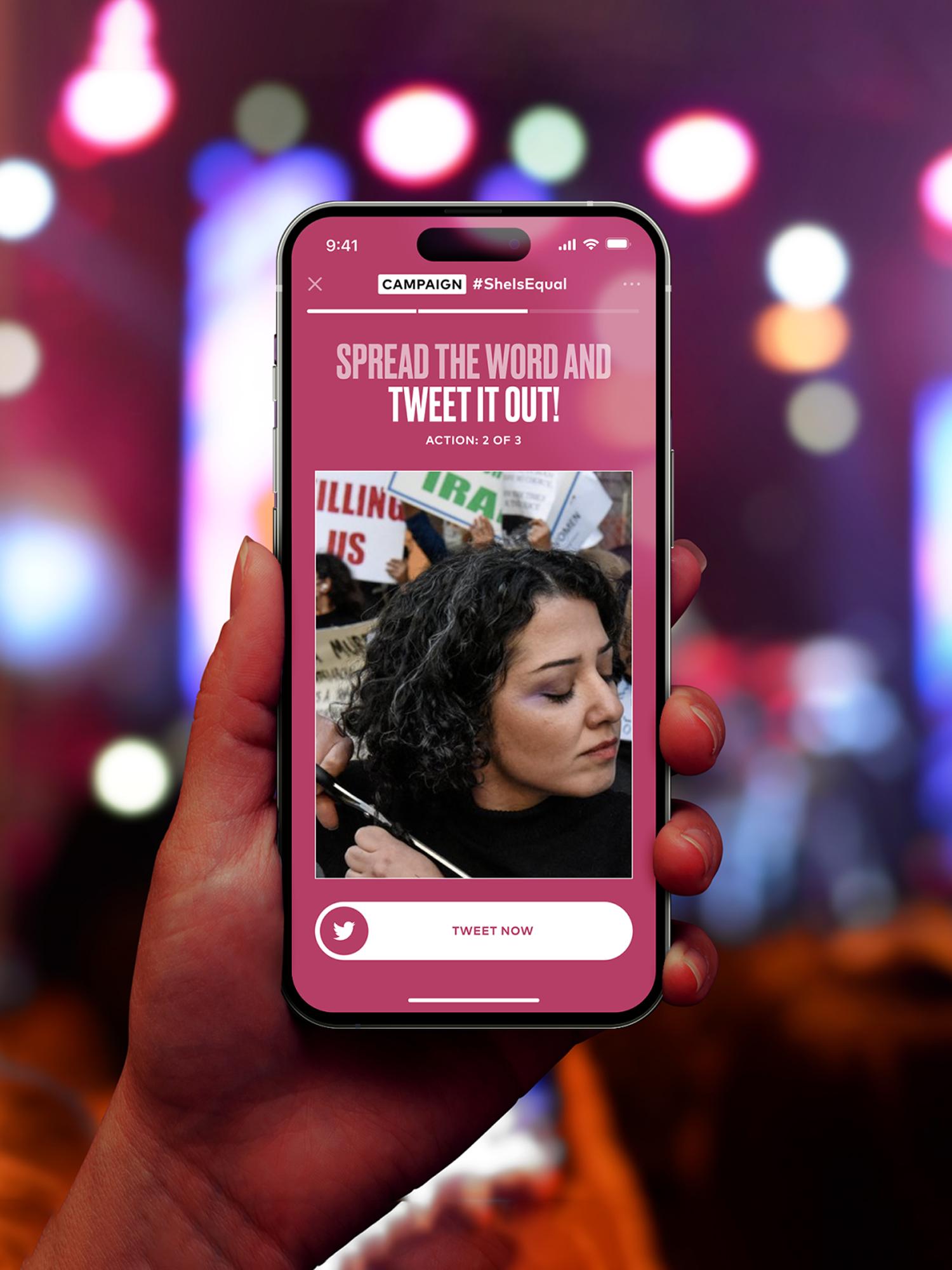 Hand holding smartphone with social campaign screen prompting users to tweet, blurred city lights behind