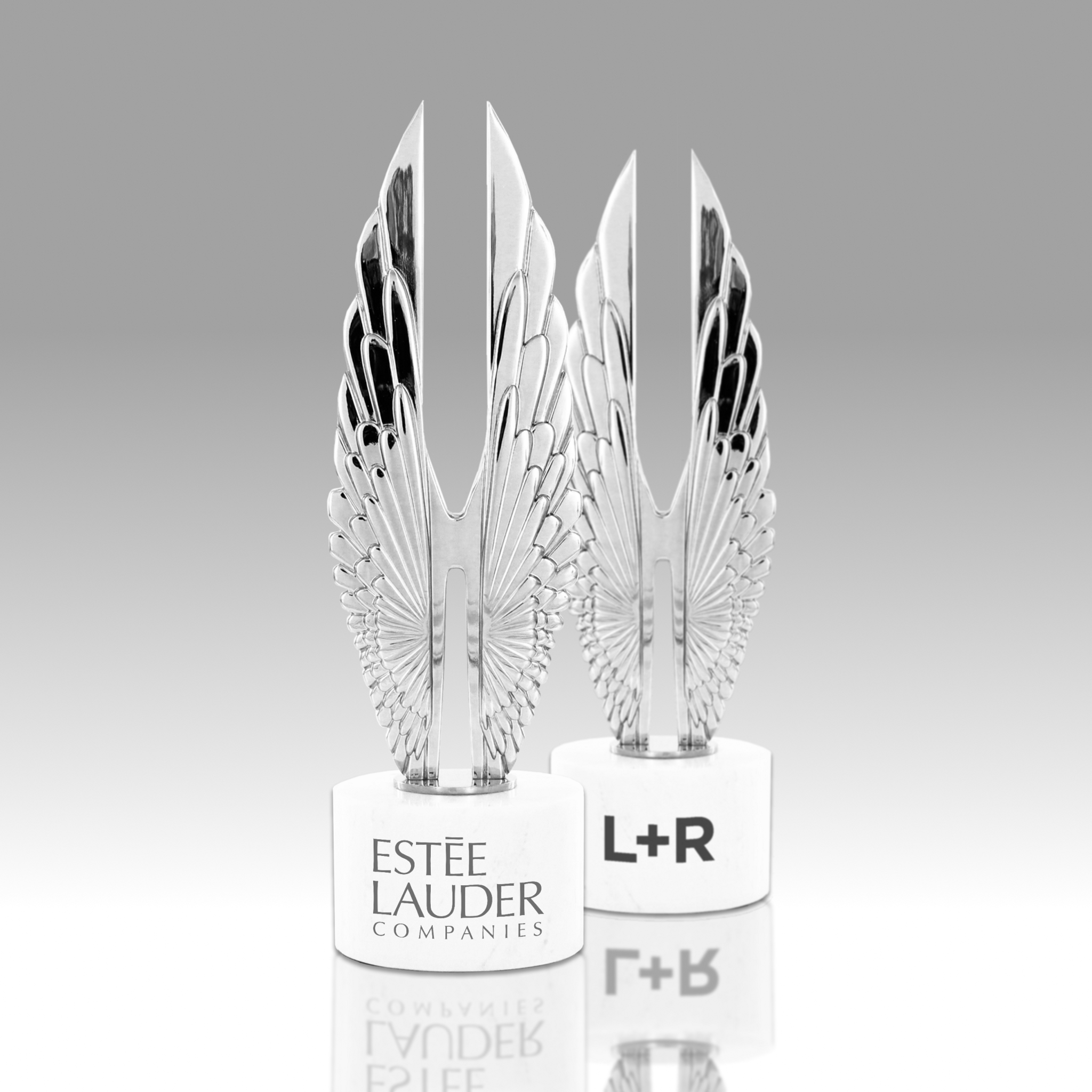 Two Hermes Creative Awards trophies labeled Estée Lauder Companies and L+R