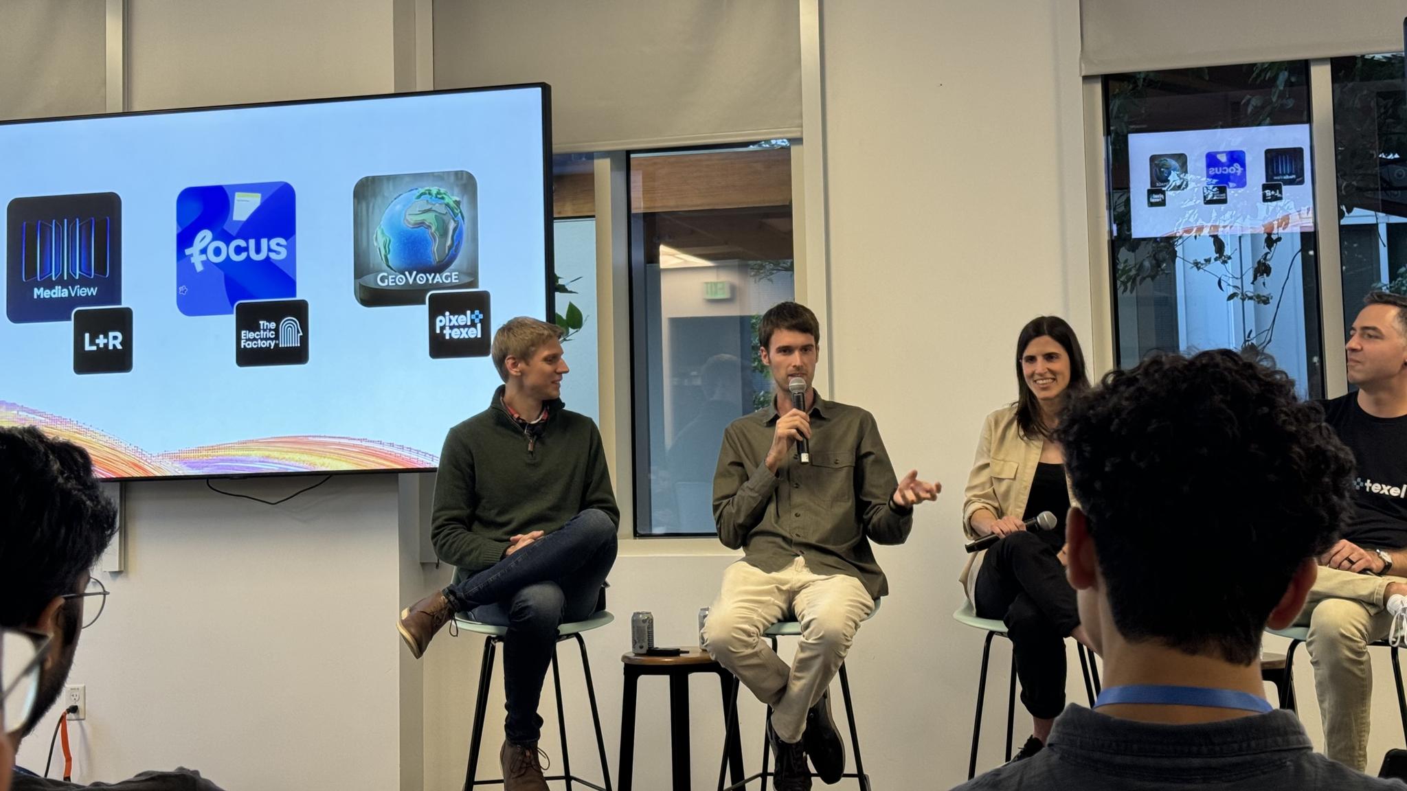 Panel discussion with app icons displayed on a wall screen