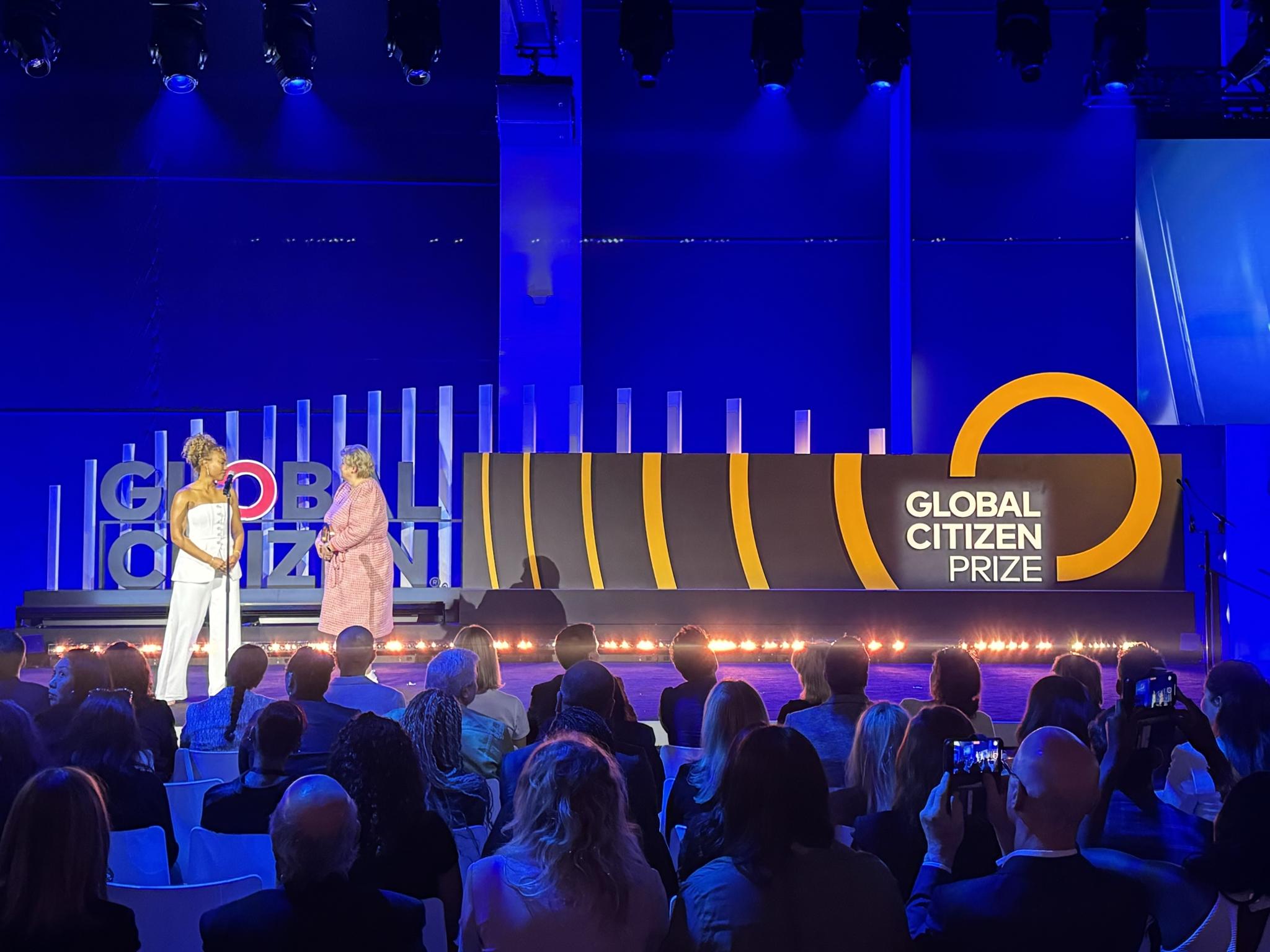 Two presenters on the Global Citizen Prize stage in front of a seated audience