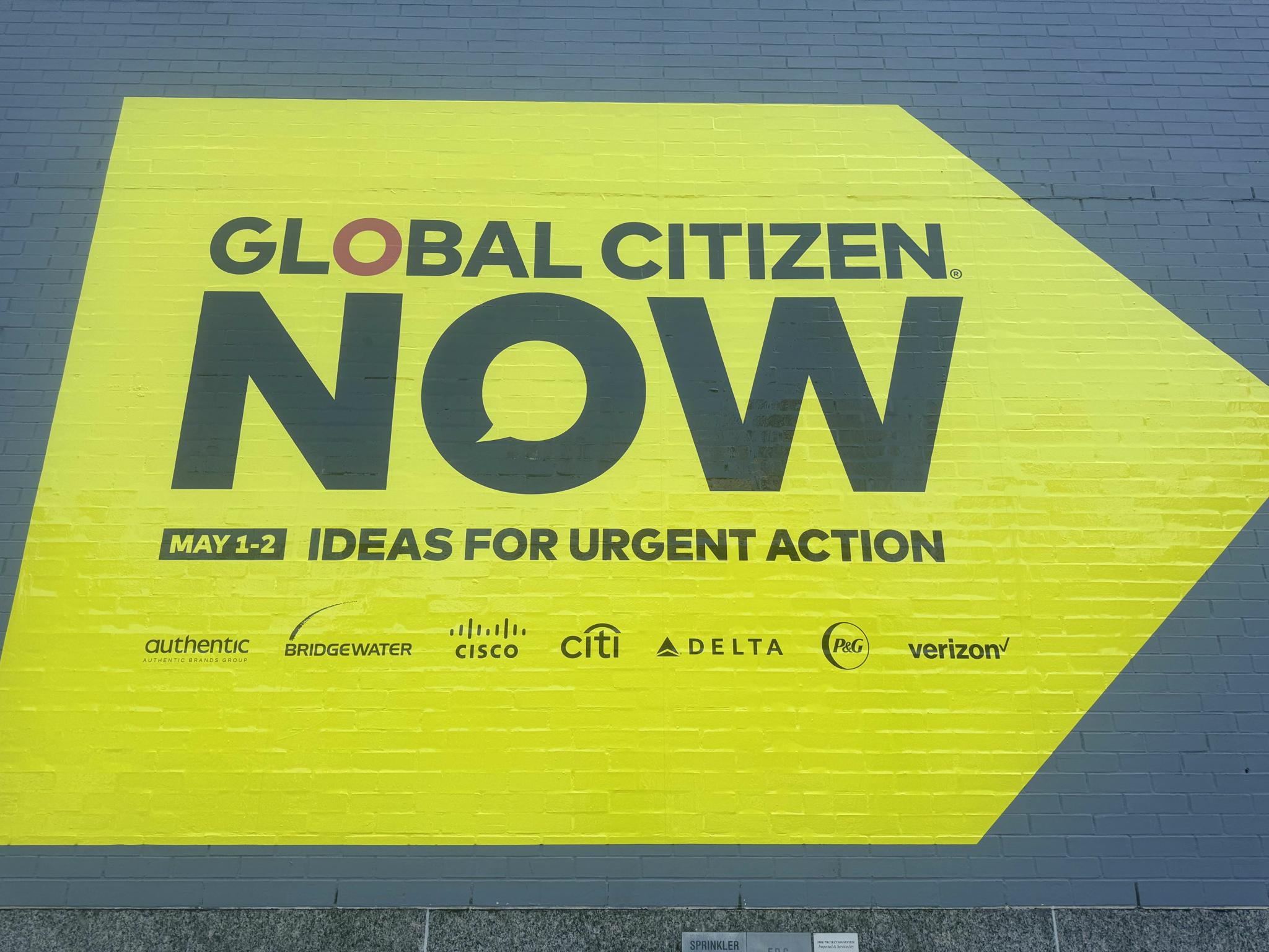 Yellow arrow mural reading "Global Citizen NOW: Ideas for Urgent Action, May 1-2"