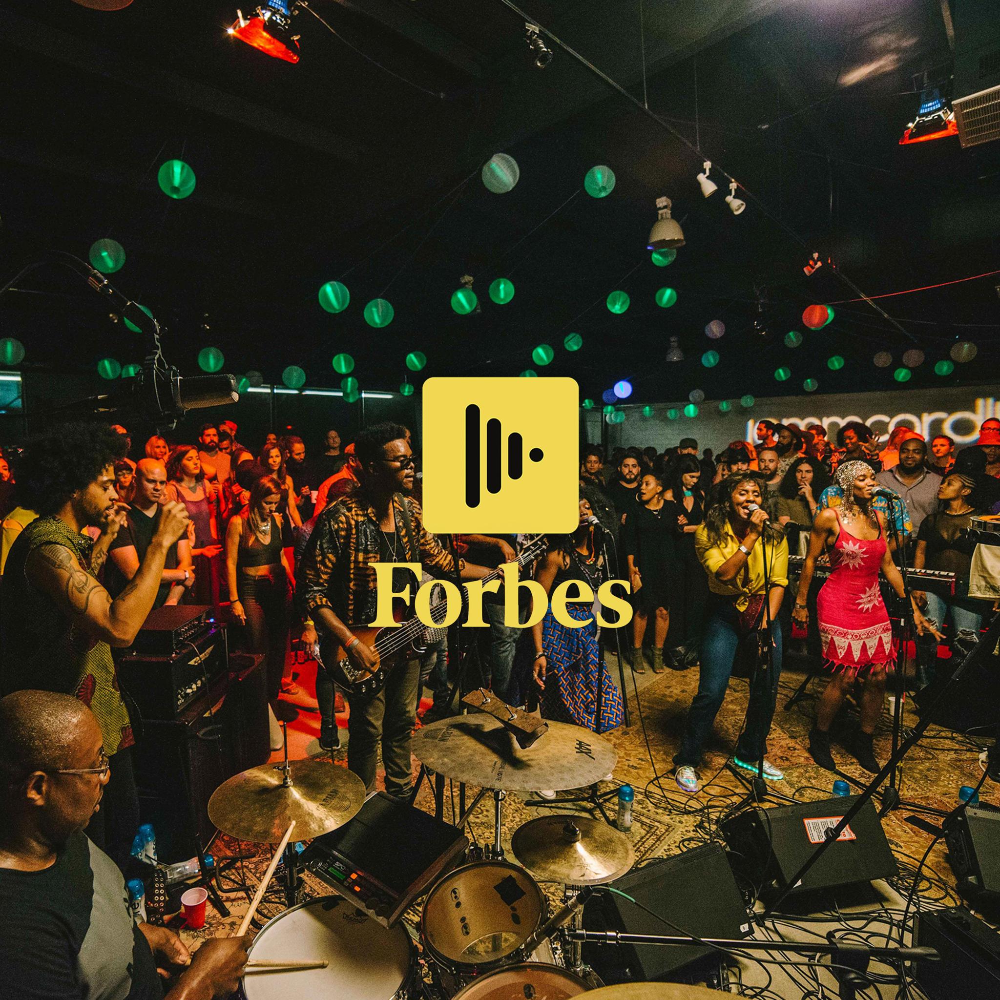 Band playing to a packed venue with the Jammcard app icon and the Forbes logo overlaid