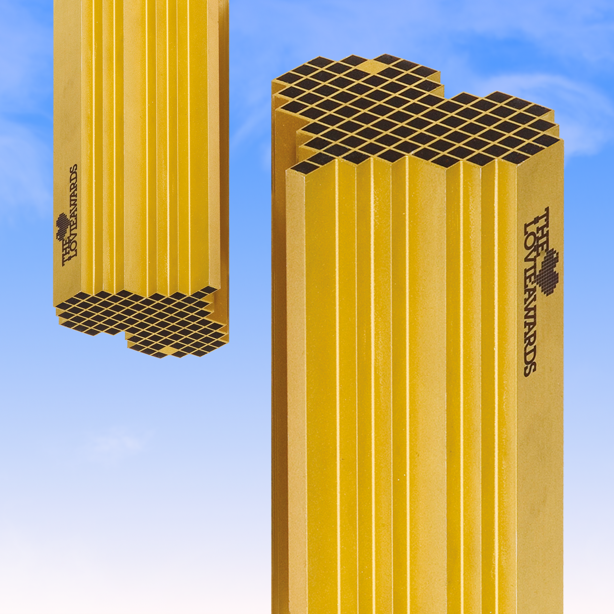 Yellow Hot Awards trophy pillars against a blue sky
