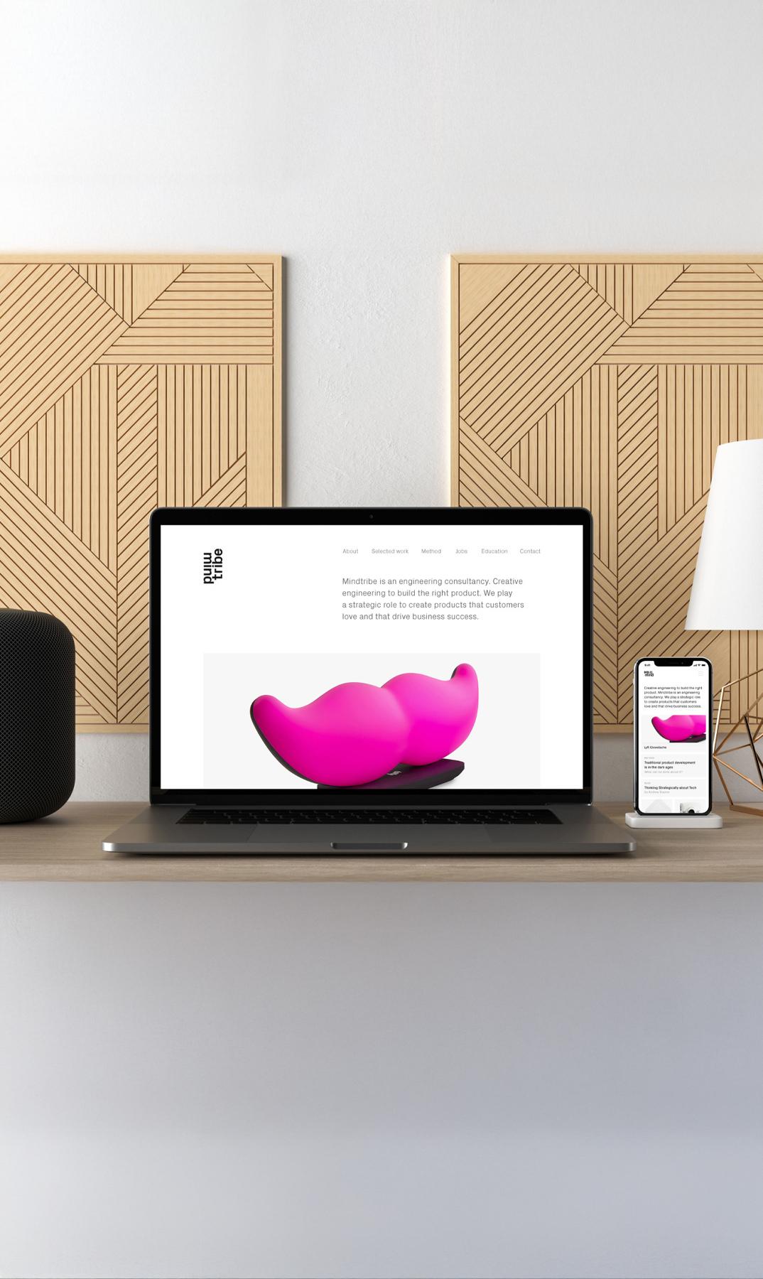 Laptop and phone on a desk showing the Mindtribe homepage