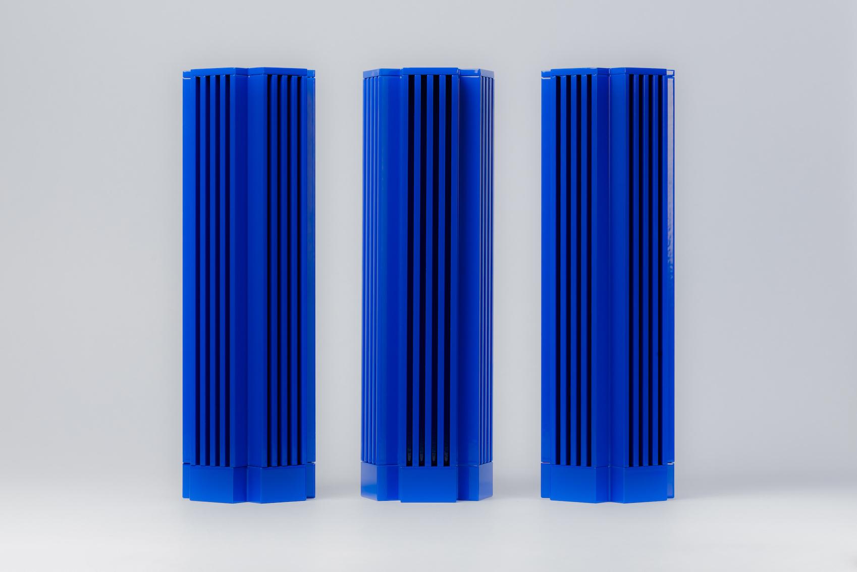 Three blue DNA Paris Design Awards trophies on a light grey backdrop.
