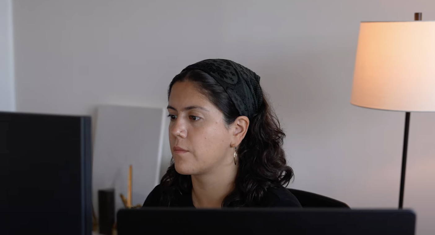 María Fernanda Quevedo at her desk, looking at a monitor