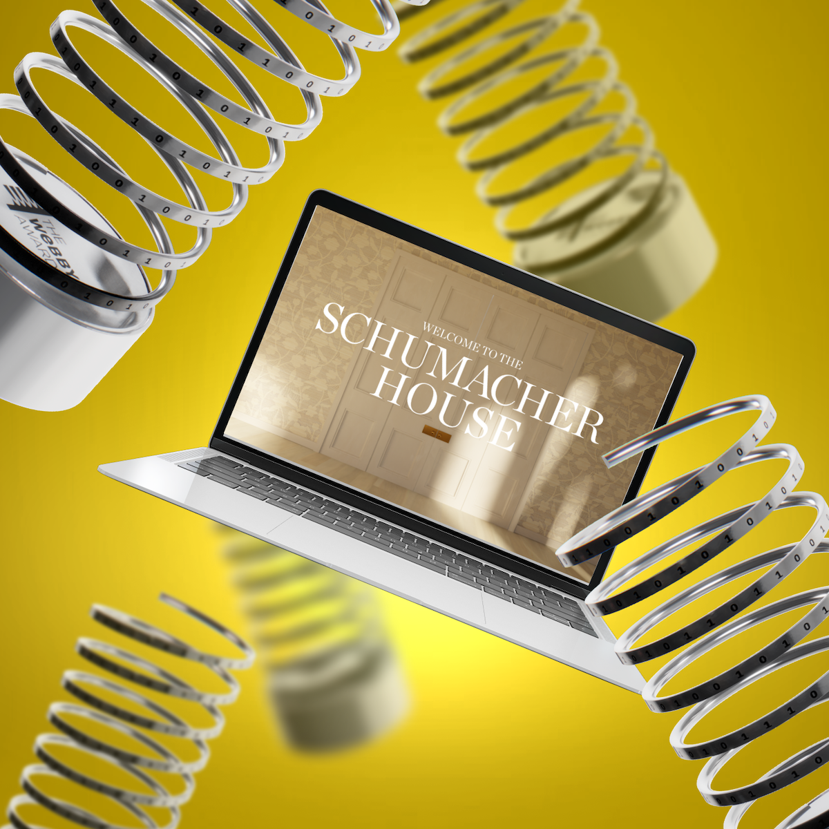 Laptop showing the Schumacher House welcome screen surrounded by floating Webby Award trophies