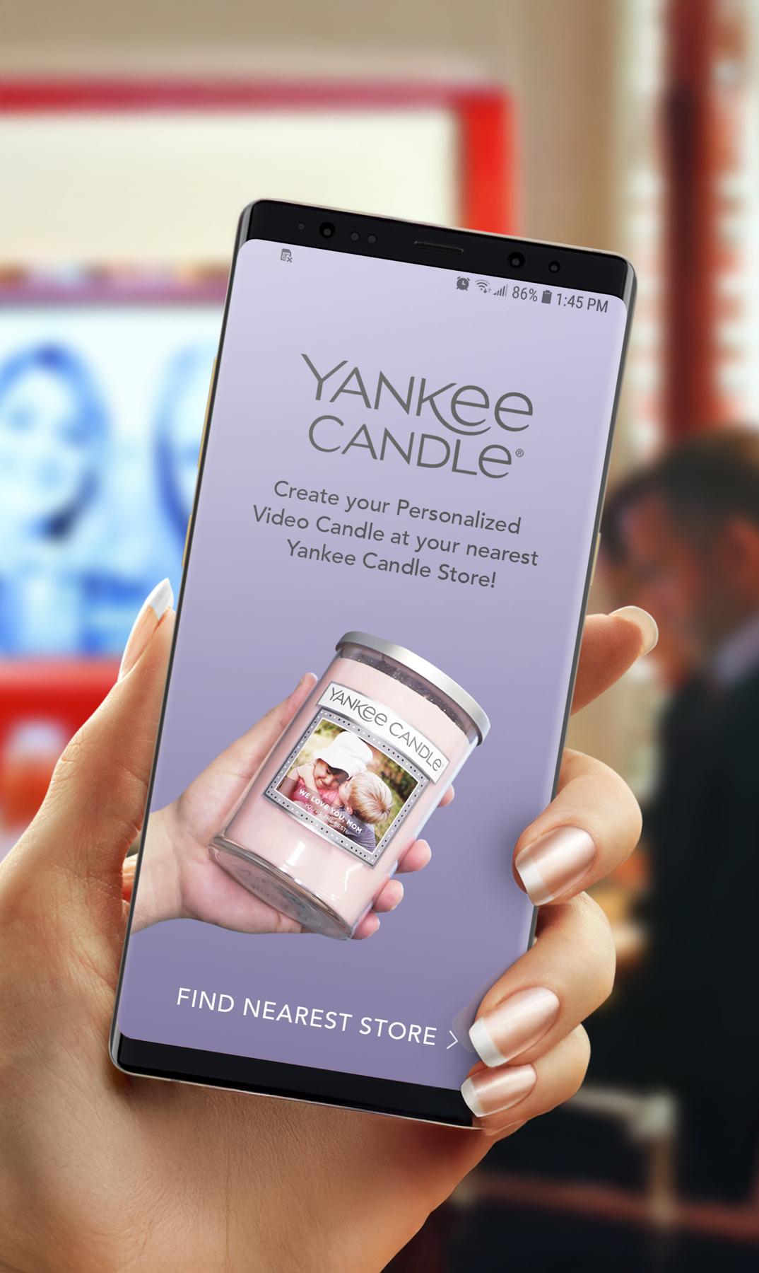 Phone showing the Yankee Candle personalised video candle app inside a Yankee Candle store