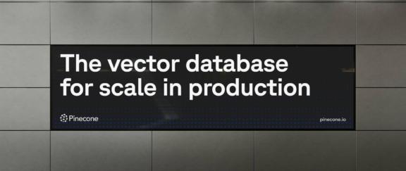 Pinecone Desktop Cover Pinecone billboard reading "The vector database for scale in production" on a metal-panelled wall.