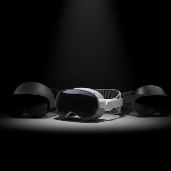 Three VR headsets displayed under a spotlight on a black background