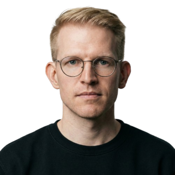 Gemini Generated Image 95jw2295jw2295jw removebg preview Headshot of a blond man with round glasses wearing a black shirt