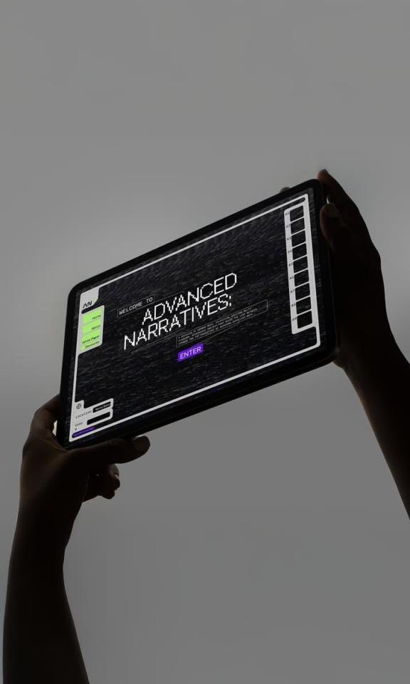 WB Adv Narratives Mobile Cover Hands hold a tablet showing an Advanced Narratives interface.