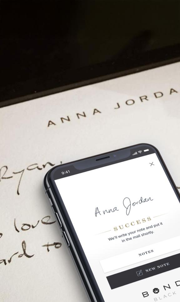 Bond Black M Cover Robotic pen handwriting a personal note while a phone shows the Bond Black app confirmation