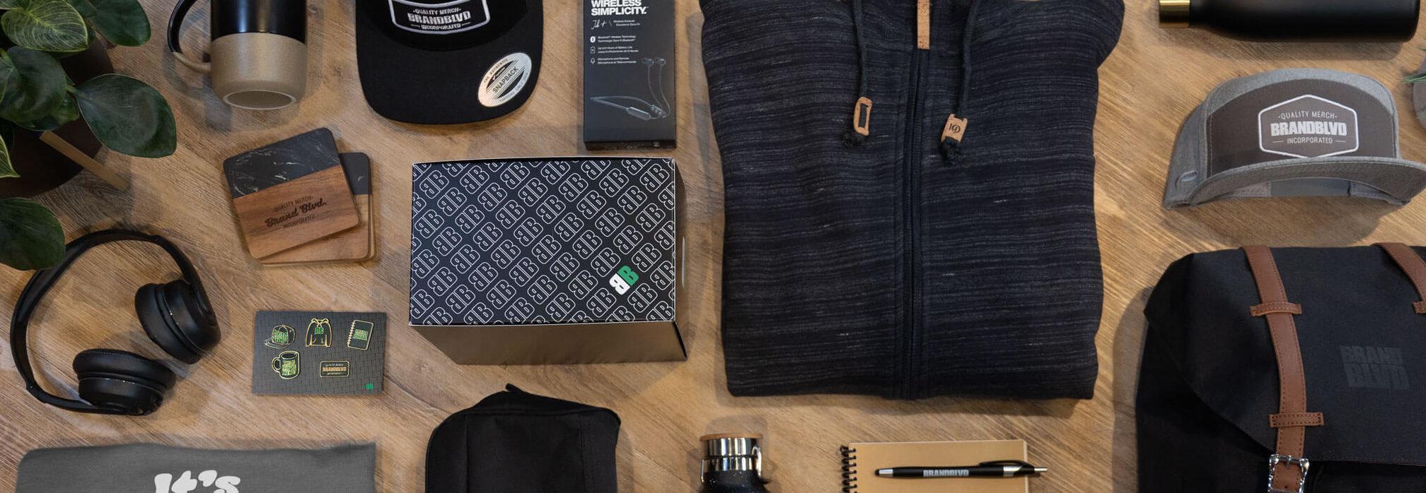Flat lay of apparel, bags, headphones, notebooks, and accessories on a wooden table