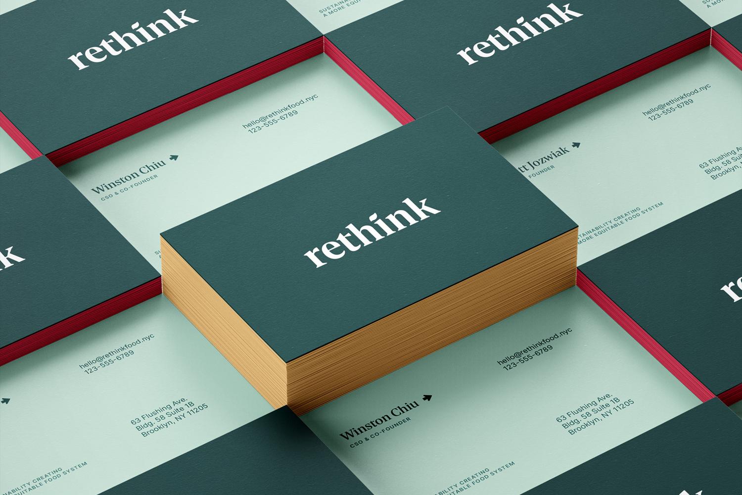 Stack of teal "rethink" business cards arranged over pale stationery with red-edged cards