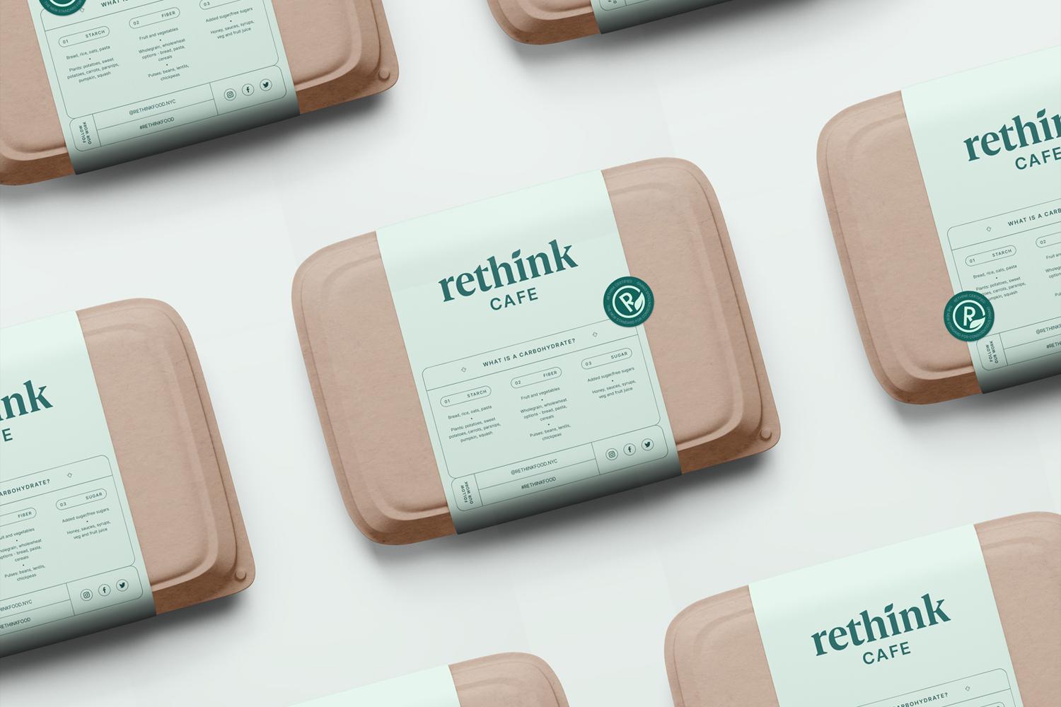Rethink Cafe takeaway meal containers with branded paper sleeves arranged on a light surface