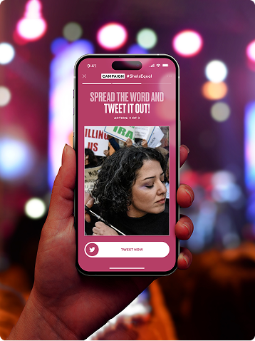 Phone showing a campaign action to spread the word and tweet, held before blurred lights