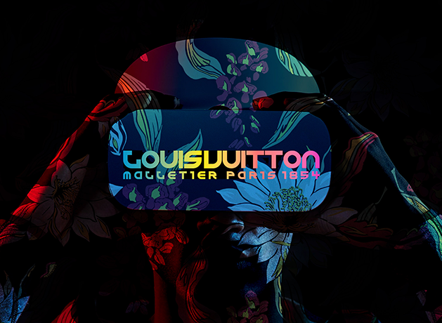 Louis Vuitton text projected on a person wearing a visor in colorful floral light