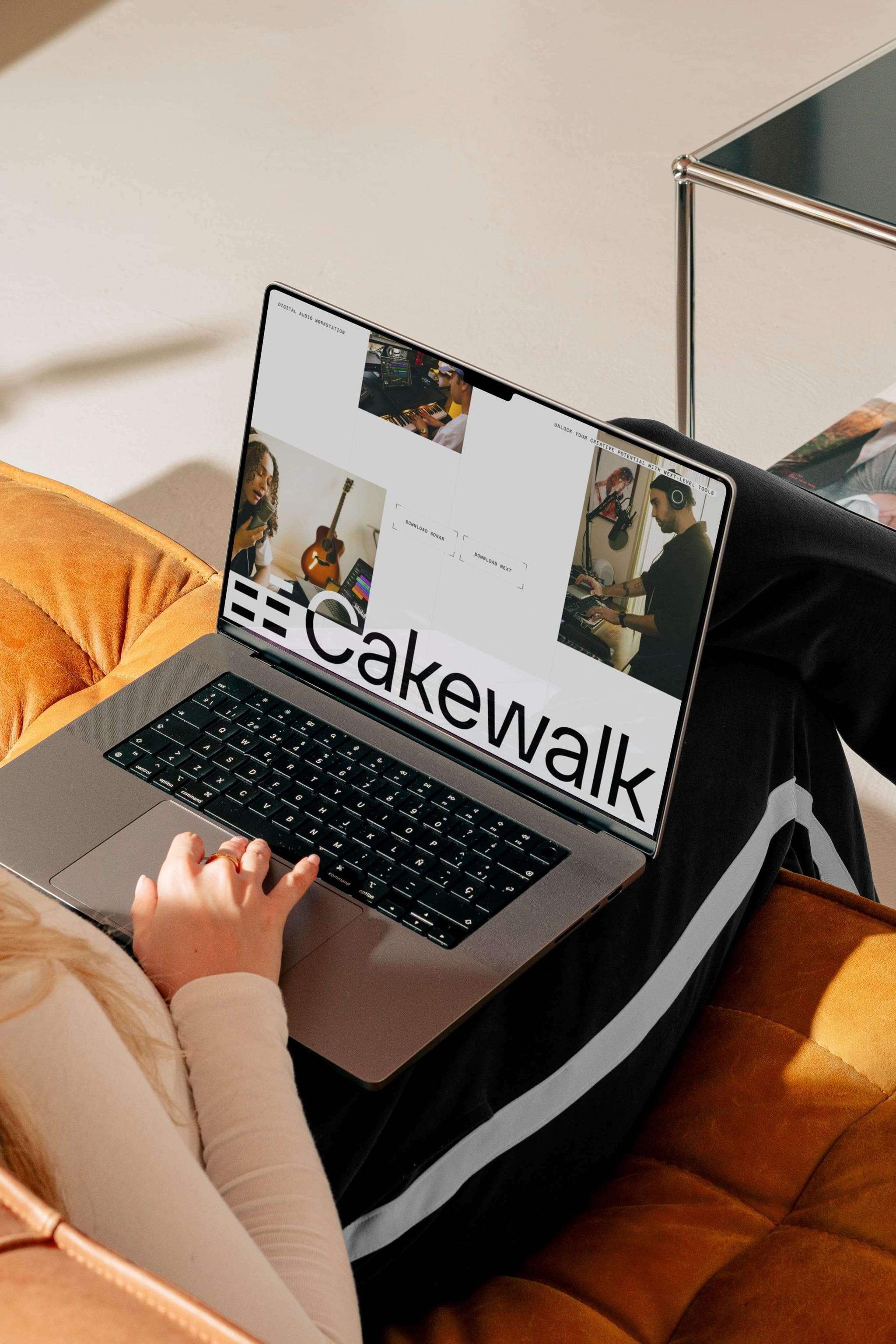 Laptop on a couch displaying Cakewalk branding and music-related visuals.
