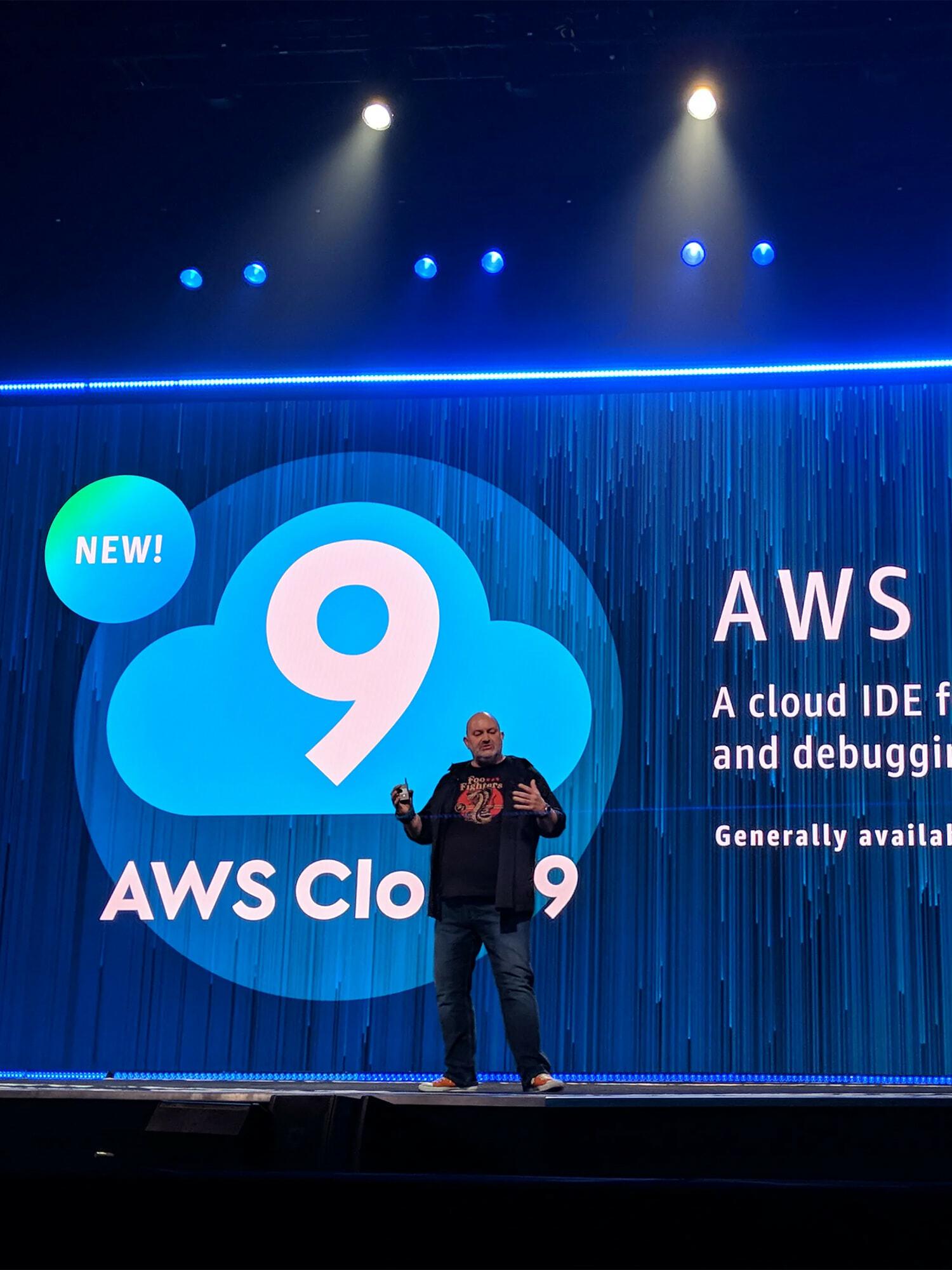 Presenter on stage introducing AWS Cloud9, a cloud IDE for writing, running, and debugging code