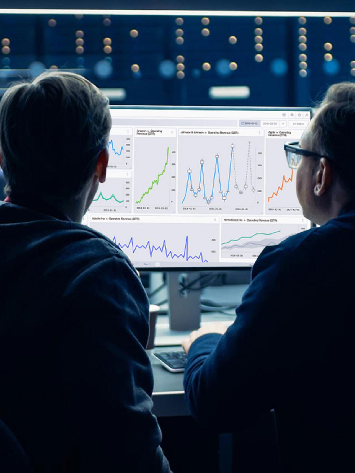Two analysts reviewing Datavore revenue dashboards across multiple monitors