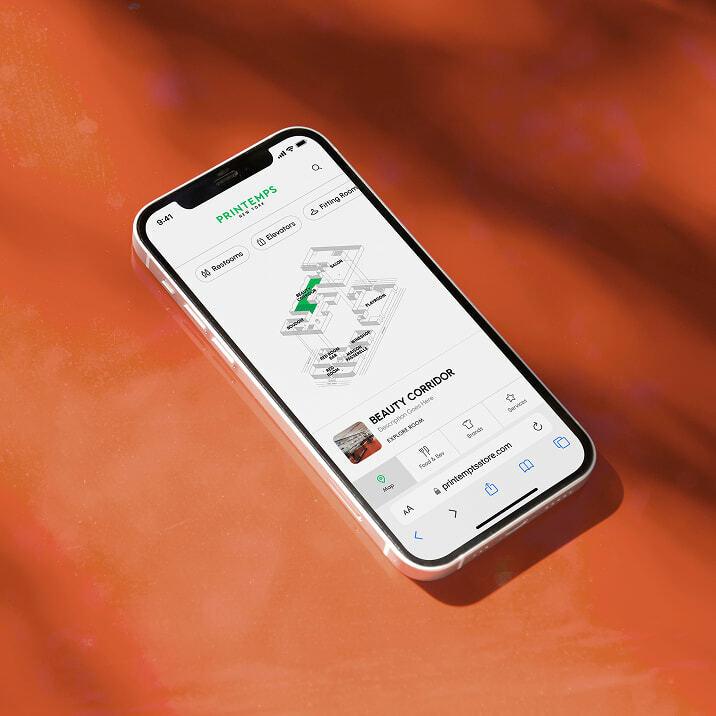 Smartphone on an orange surface showing a Printemps store map