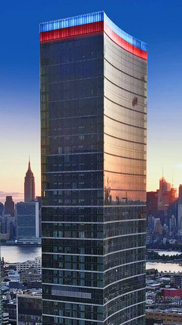 Skyscraper at sunset with red, white, and blue lighting along the top edge