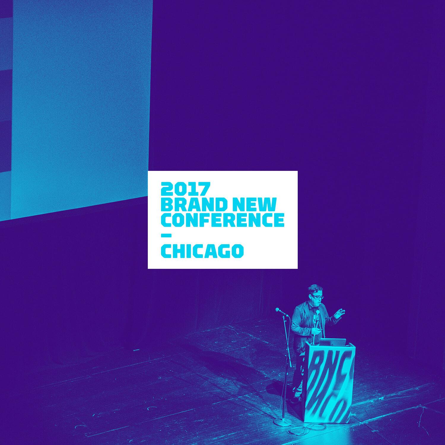 Speaker at a podium on a purple-lit stage with the 2017 Brand New Conference Chicago screen