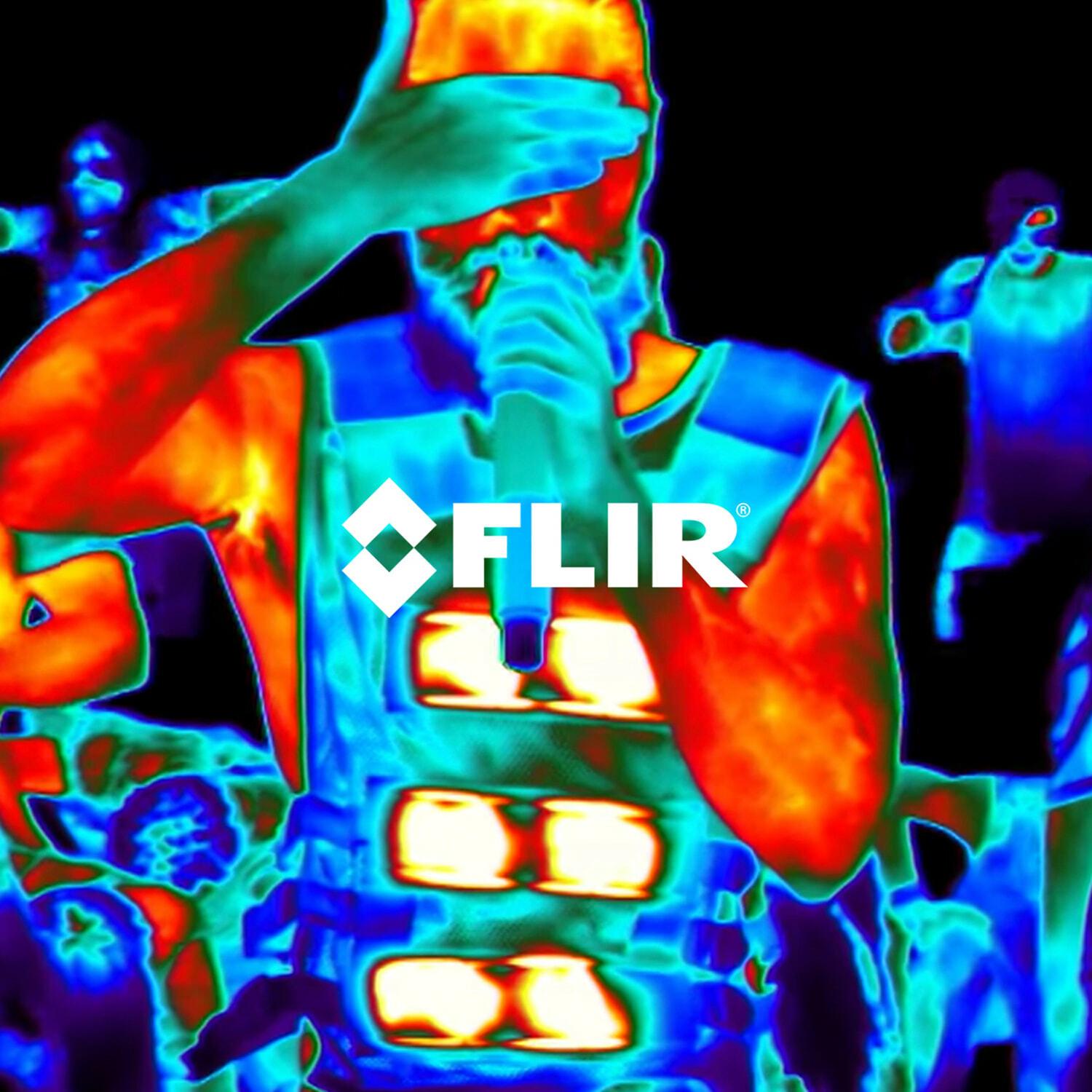 Thermal camera view of a performer singing into a microphone amid a crowd, with FLIR logo overlaid
