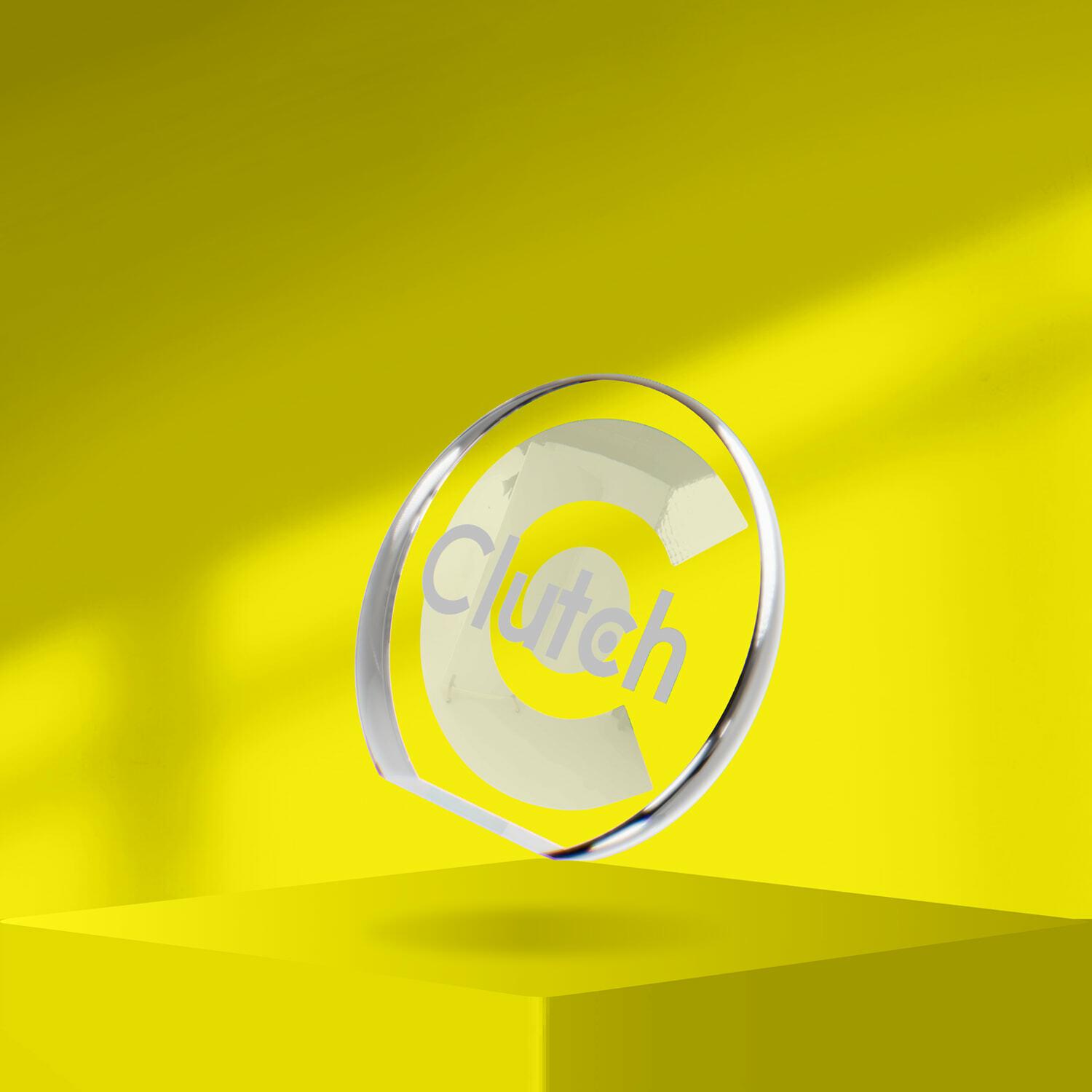Clutch glass award floating above a yellow pedestal