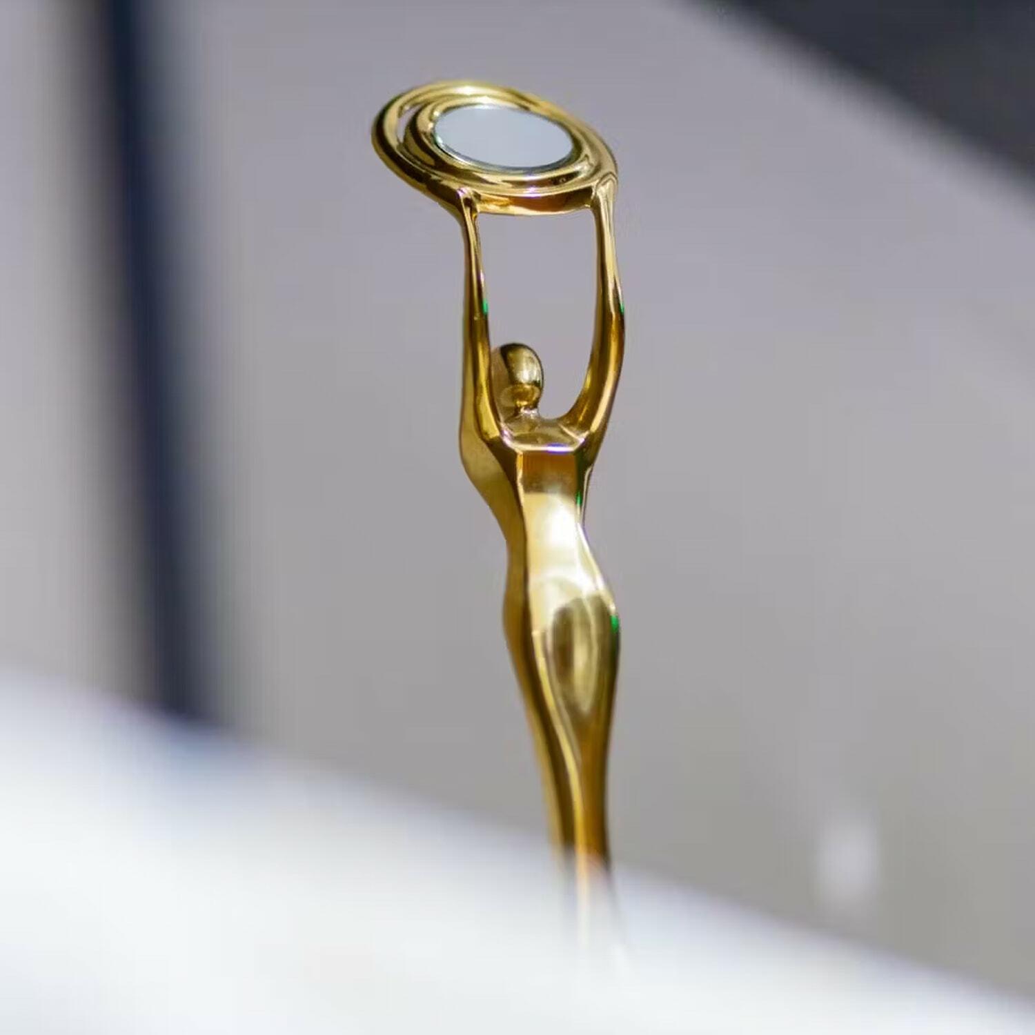 Gold statuette trophy holding a circular ring