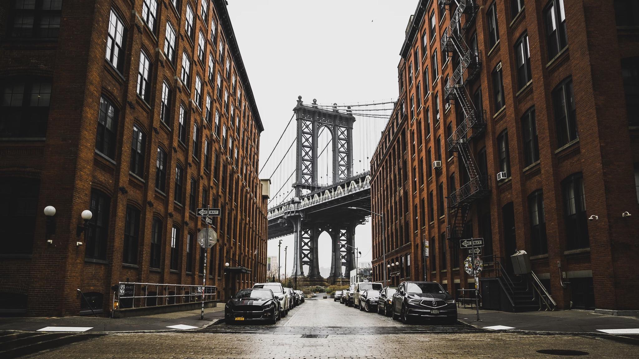 Cobblestone street between brick buildings leading to the Manhattan Bridge