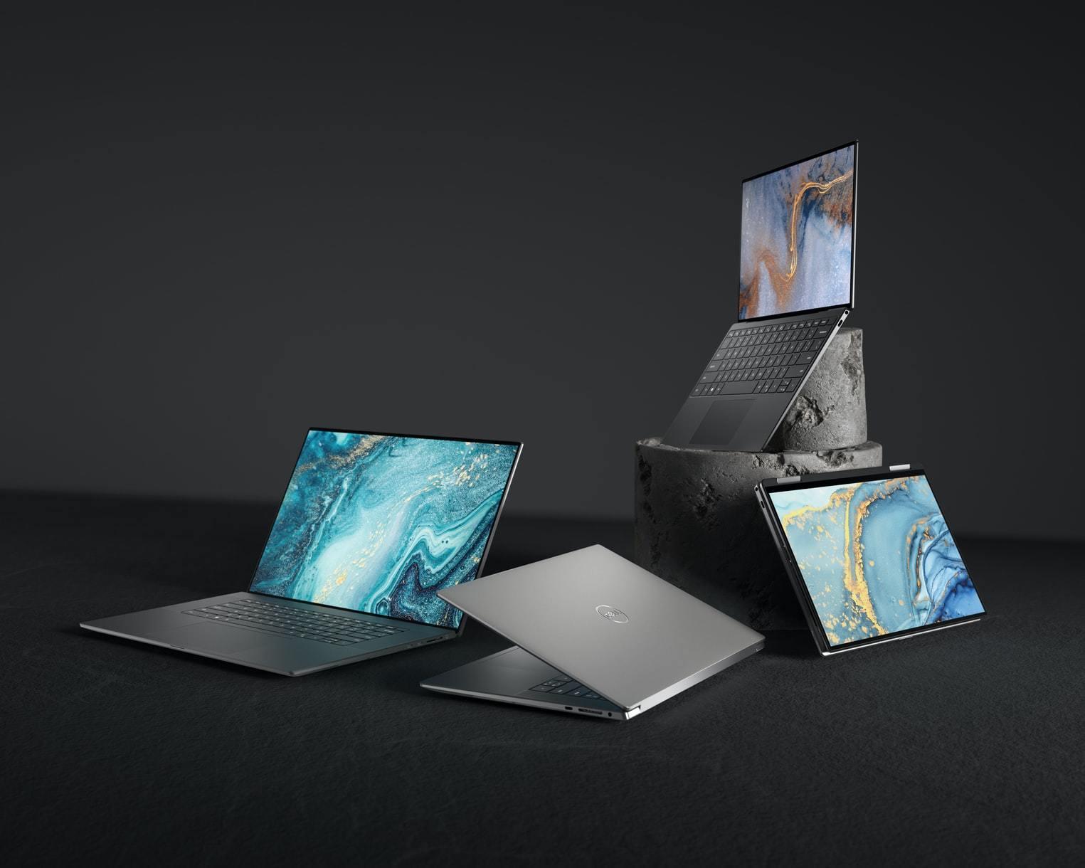 Four laptops with marbled wallpapers arranged on a dark studio set