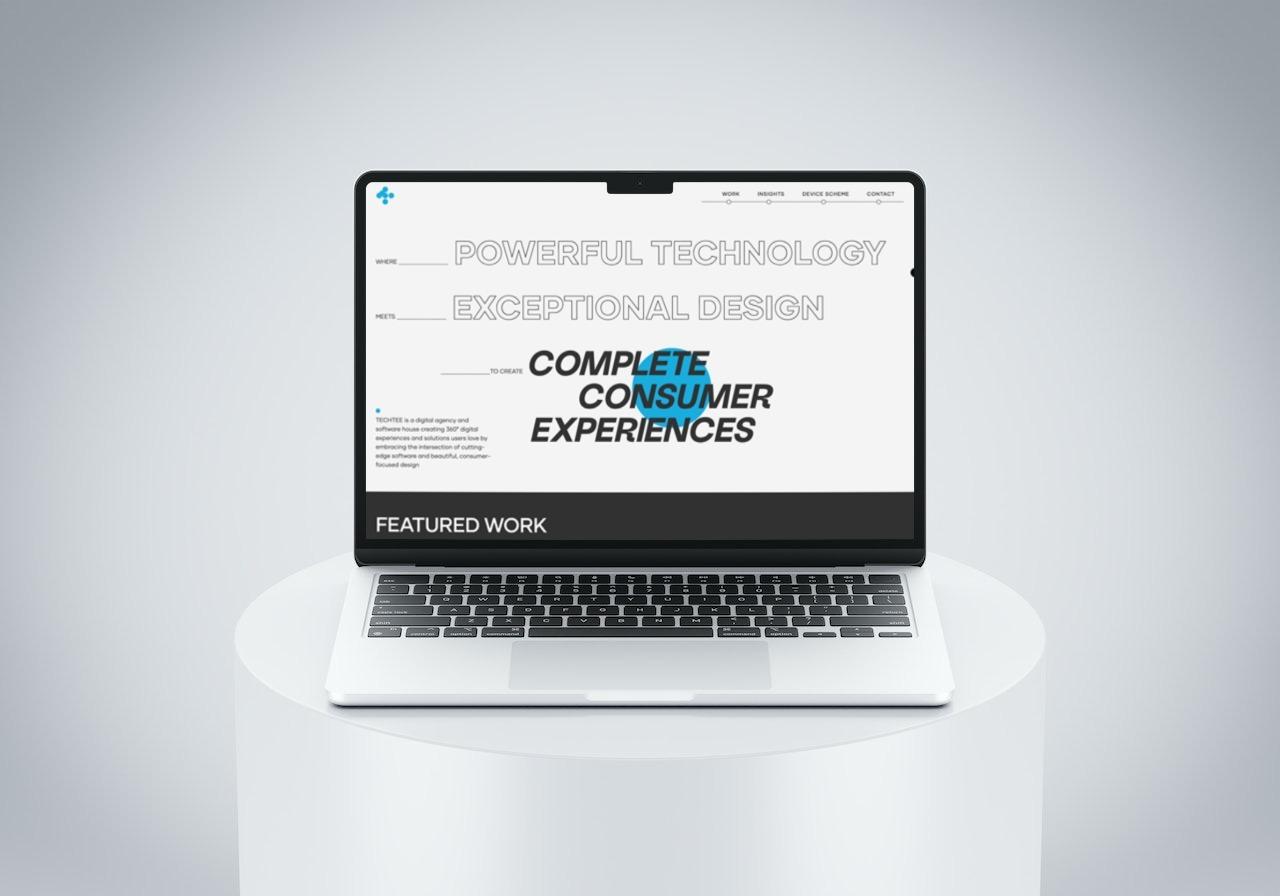 Laptop displaying a design agency website on a white pedestal